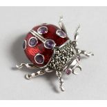 A SILVER, RED ENAMEL AND AMETHYST LADYBIRD BROOCH.