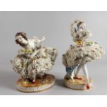 A PAIR OF CONTINENTAL PORCELAIN FIGURES OF DANCERS, wearing floral encrusted dresses. 7ins and 9.