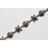 A SILVER, GARNET AND MARCASITE FLOWER HEAD BRACELET. 7ins long.