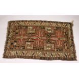 A PERSIAN CAUCASIAN RUG, EARLY 20TH CENTURY, with three large cross shaped medallions, within a