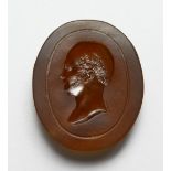 AN INTAGLIO CARVED AMBER GLASS BUST OF A MAN, in the Roman style. 2ins high.