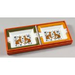 A PAIR OF HERMES PORCELAIN ASHTRAYS, decorated with leopards, in a Hermes box.