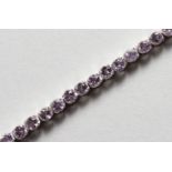 A SILVER AND AMETHYST LINE BRACELET. 7ins long.