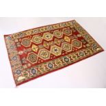 A MODERN PERSIAN RUG, rust ground with two rows of five large medallions. 6ft 3ins x 3ft 11ins.