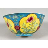 A CHINESE PORCELAIN BOWL, blue ground, painted with panels of flowers. 6ins diameter.