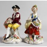 A PAIR OF SITZENDORF FIGURES, a seated man with basket of flowers, and a seated girl with a flower