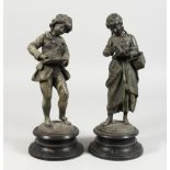 A PAIR OF 19TH CENTURY METAL STRIDING FIGURES, a young scribe, on circular bases. 13ins high.