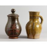 A 19TH CENTURY TERRACOTTA JUG, part glazed, with applied moulded decoration, and a pottery jar and