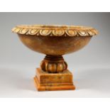 A LATE 19TH CENTURY CARVED MARBLE PEDESTAL URN, on a square base. 10.5ins diameter.