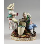 A GOOD MEISSEN PORCELAIN GROUP OF A YOUNG BOY AND GIRL, the boy seated beside and holding fruiting