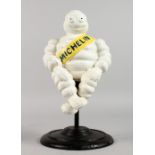 A PAINTED CAST IRON MICHELIN MAN, on a stand.