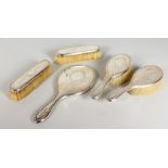 A FIVE PIECE ENGRAVED SILVER DRESSING TABLE SET, comprising hand mirror and four brushes. London