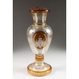 A LATE 19TH CENTURY BOHEMIAN AMBER TINTED GLASS LAMP BASE, engraved with a stately home and fruiting