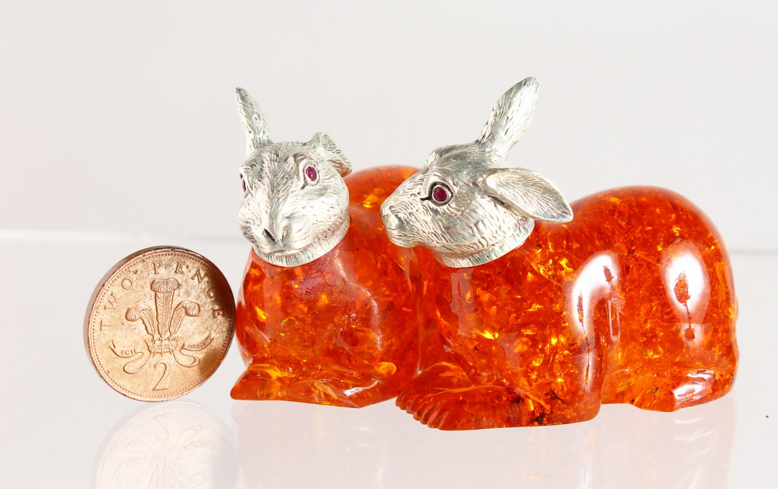 A PAIR OF NOVELTY AMBER AND .800 RABBITS.