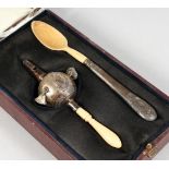 A VICTORIAN BABIES SILVER AND IVORY RATTLE, with whistle and a spoon in a fitted leather case.