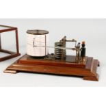 A BAROGRAPH in a glass case.