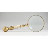 A LARGE MAGNIFYING GLASS, with brass and mother-of-pearl handle.