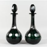 A GOOD PAIR OF GREEN CUT GLASS DECANTERS AND STOPPERS. 14ins high.