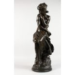 MOREAU A BRONZE-LIKE FIGURE OF A SEATED SEMI-NUDE YOUNG LADY, on a circular base. Signed. 25ins