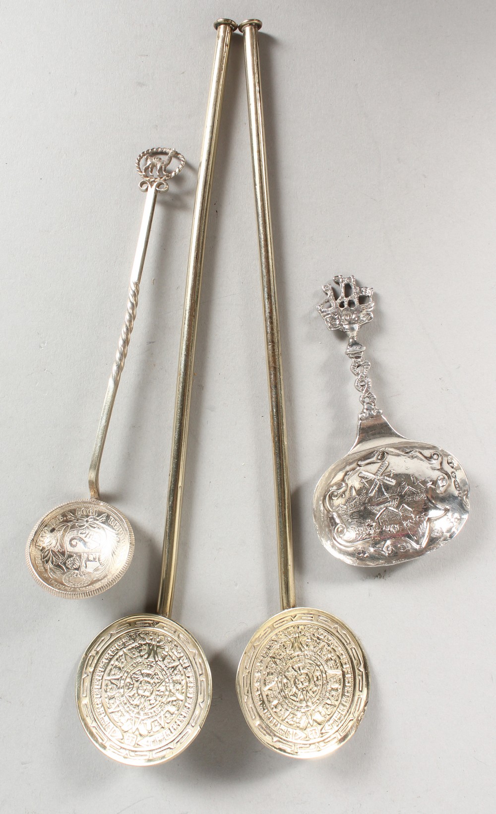 A PAIR OF STERLING SILVER GILT SPOONS, a caddy spoon and a coin spoon (4).