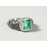 A VERY GOOD 18CT WHITE GOLD AND EMERALD RING, with diamond and sapphire shanks.