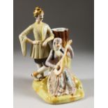 A RUSSIAN STYLE PORCELAIN VASE GROUP of a man standing and a lady playing a guitar. 10ins high.
