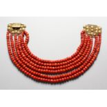 A GOOD SIX STRAND CORAL BEAD NECKLACE, with 18ct gold filigree clasp.