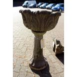 A reconstituted stone pedestal planter