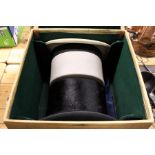 A hat box containing a black silk top hat and a grey top hat