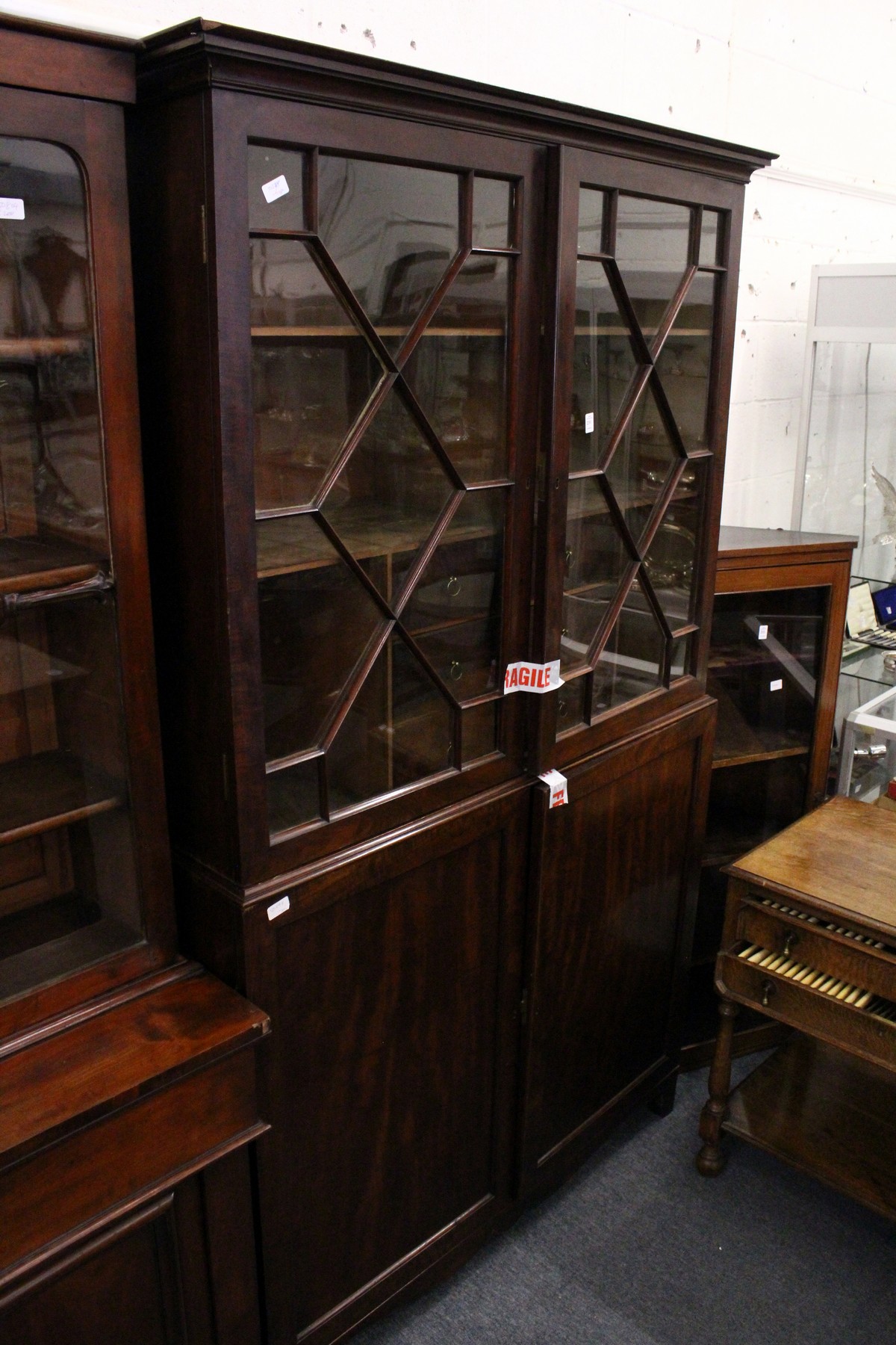 A 19th century mahogany floor standing cabinet with glazed doors above a pair of panelled doors