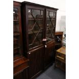 A 19th century mahogany floor standing cabinet with glazed doors above a pair of panelled doors