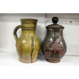 A pottery jug and similar jar and cover