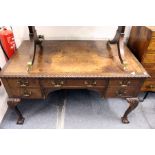 A mahogany writing desk with leather inset top central long drawer flanked by small drawers on