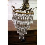 The matching larger brass and cut glass single chandelier