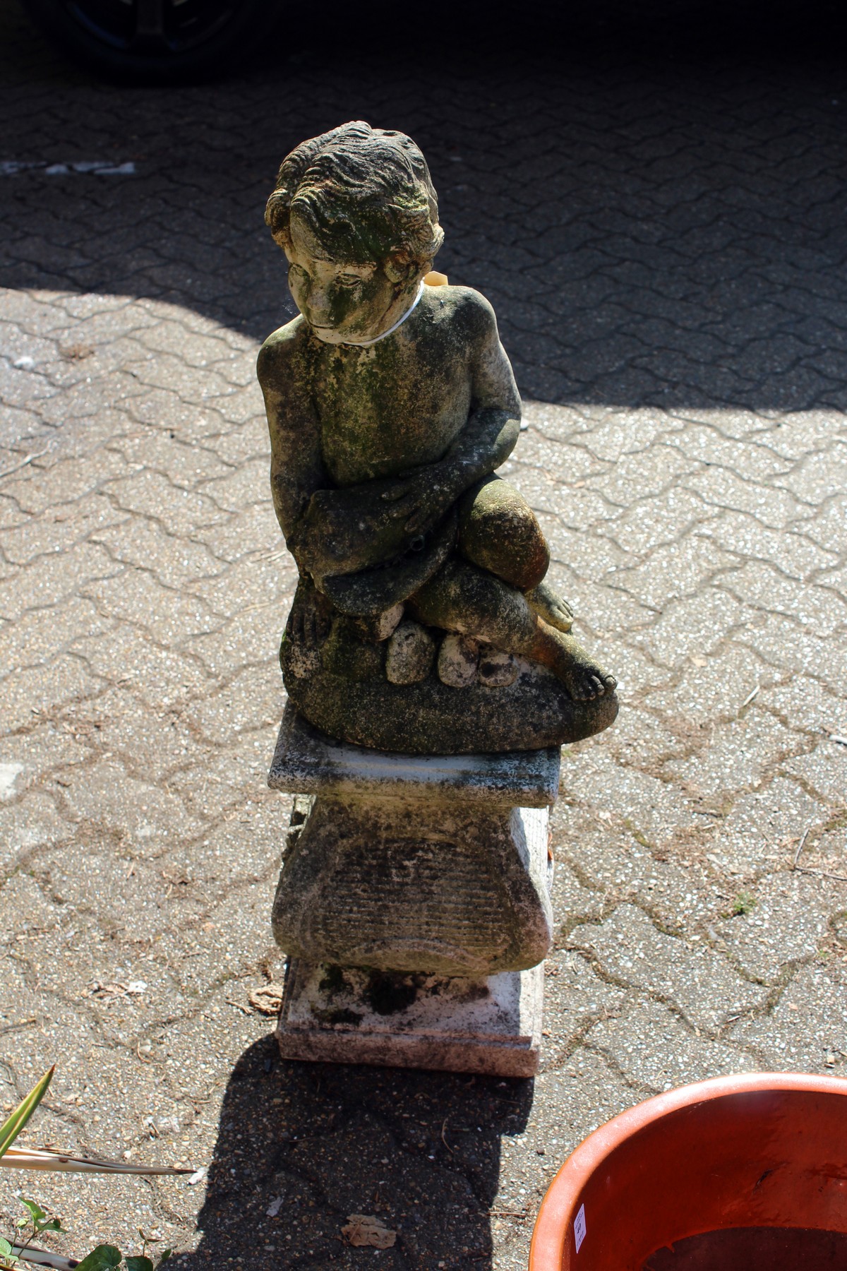 A reconstituted stone cherub fountain on a pedestal base