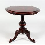 A miniature tilt top tripod table