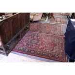 A good pair of Persian rugs probably Isfahan claret ground with stylised decoration