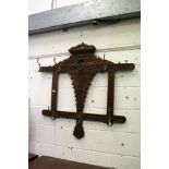 A carved oak hall rack with brass hooks