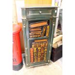 A pedestal cupboard the door painted and moulded as a stack of books