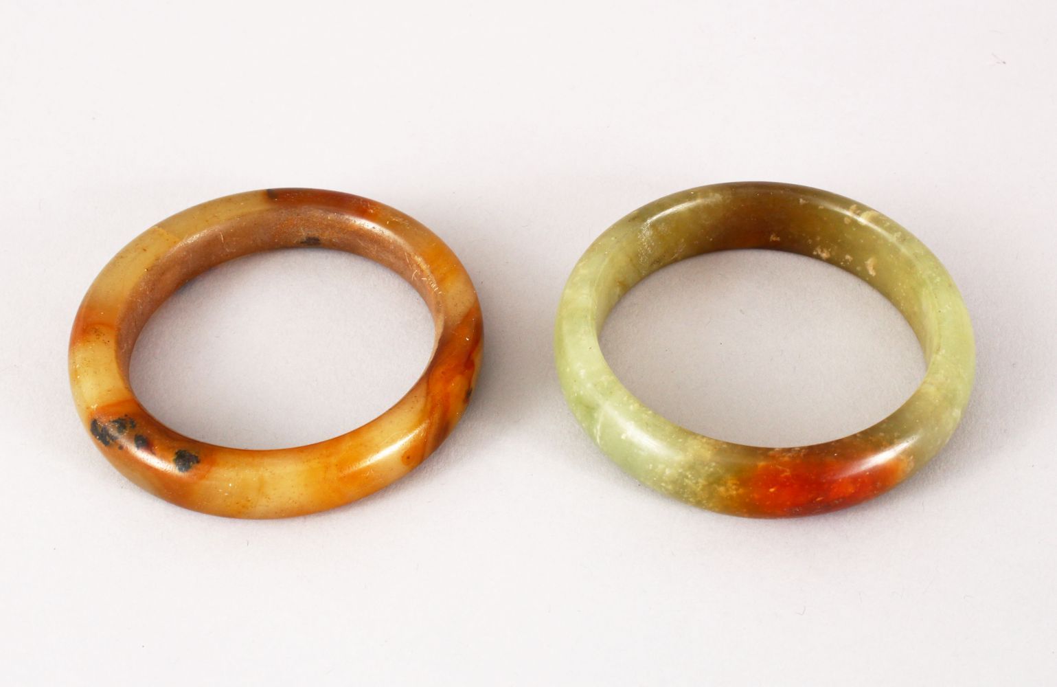 TWO 19TH / 20TH CENTURY CHINESE CARVED JADE BANGLES, both 8.5cm & internal 6cm & 6.5cm