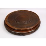 A HUGE 19TH CENTURY CHINESE CARVED HARDWOOD STAND, of cylindrical form with carved apron, housing