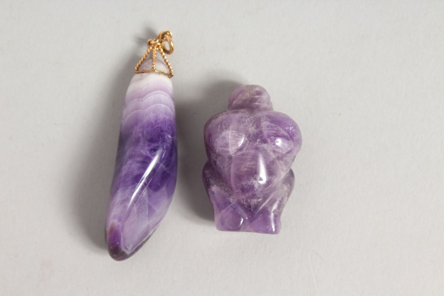 TWO CHINESE AMETHYST COLOURED STONE / CRYSTAL PENDANT AND FIGURE OF A BUST, 6cm & 3.5cm.