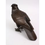 A JAPANESE MEIJI PERIOD BRONZE OKIMONO OF A HAWK, the hawk looking back, 6cm high x 21cm wide.