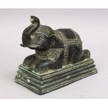 AN EARLY INDIAN OR SOUTH EAST ASIAN BRONZE FIGURE OF AN ELEPHANT, in a recumbent position, 15cm high