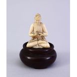 A SMALL 19TH CENTURY CARVED INDIAN IVORY FIGURE OF A DEITY, on a wooden base, 5cm.