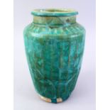 A LARGER ISLAMIC TURQUOISE GLAZED POTTERY VASE, with a ribbed body, 29cm high.