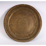 A 19TH CENTURY INDAIN BRASS CHARGER / DISH, with embossed decoration, 23cm