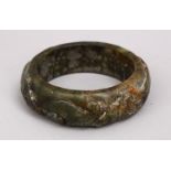 A CHINESE CARVED JADE BANGLE, carved in archaic form, 9cm