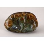 A 19TH CENTURY CARVED CHINESE GREEN JADE / JADELIKE PEBBLE OF A PEACH BLOSSOM AND LOTUS, 7.5cm