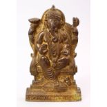 A GOOD INDIAN GILT BRONZE FIGURE OF GANESH, seated, 26cm